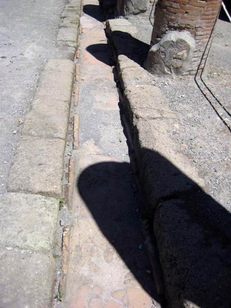 Decumanus Maximus, north side, Herculaneum, June 2011.
Looking west along drainage channel on north side at west end. Photo courtesy of Sera Baker.